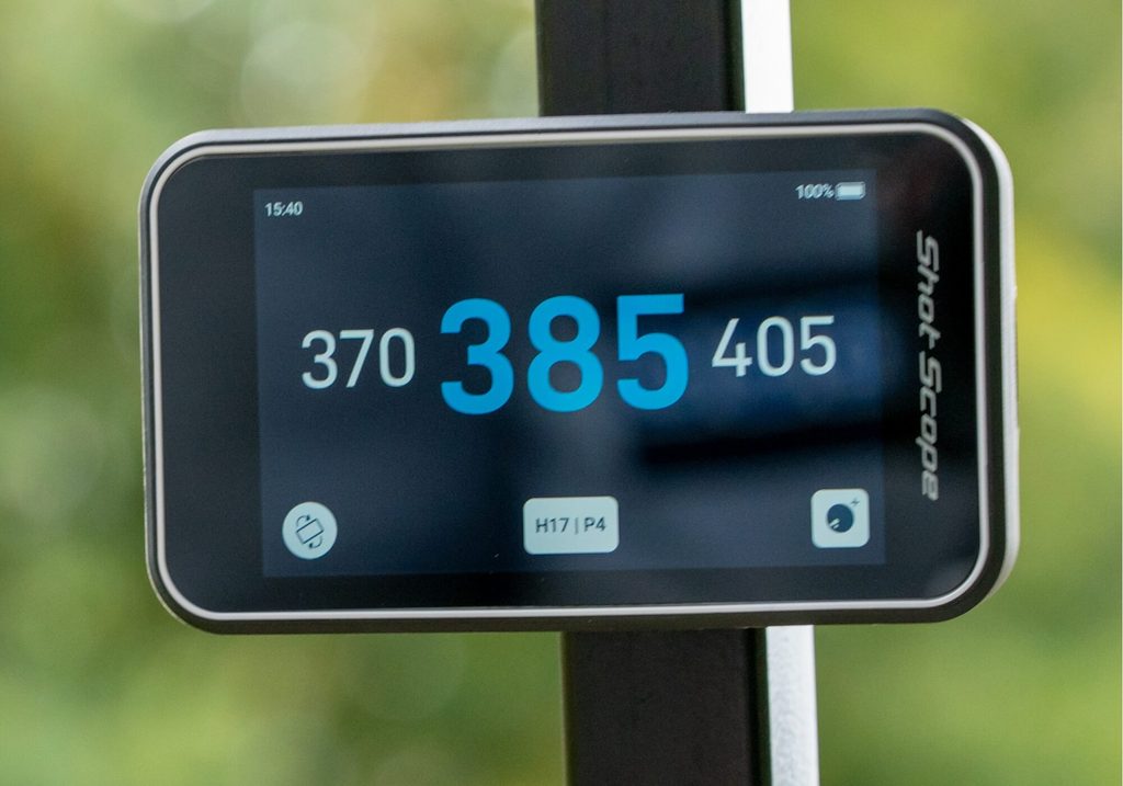 Shot Scope H50 handheld golf GPS being used on a golf course showing a full-colour hole map and yardages