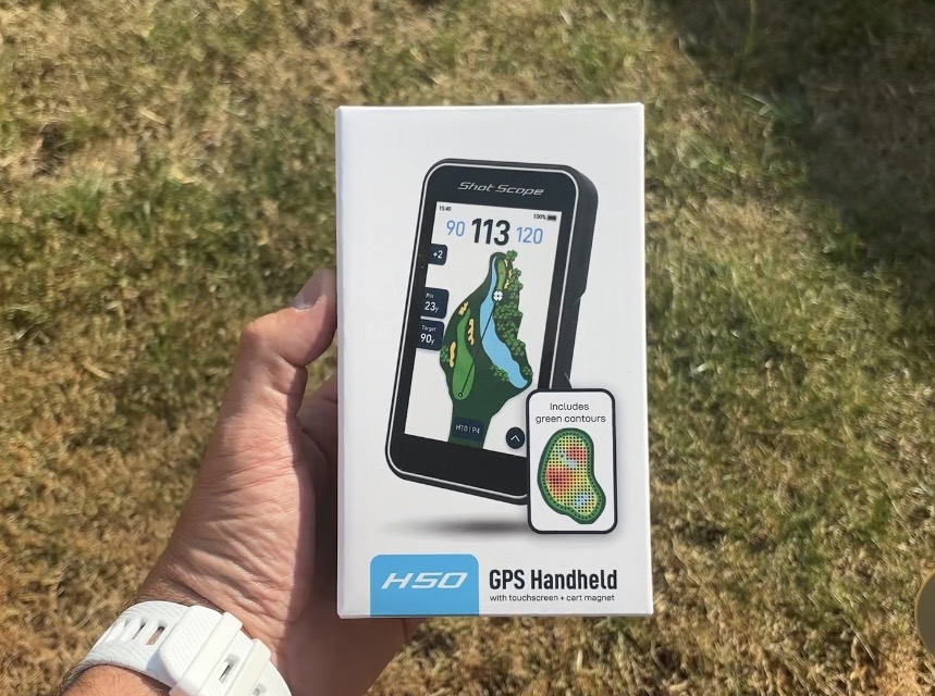 Shot Scope H50 handheld golf GPS being used on a golf course showing a full-colour hole map and yardages