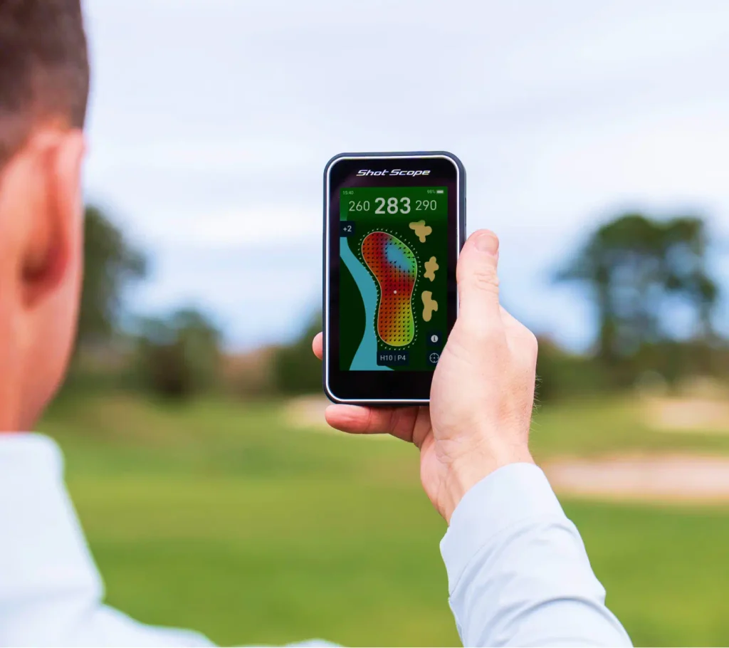 Shot Scope H50 handheld golf GPS being used on a golf course showing a full-colour hole map and yardages. Green contours. 